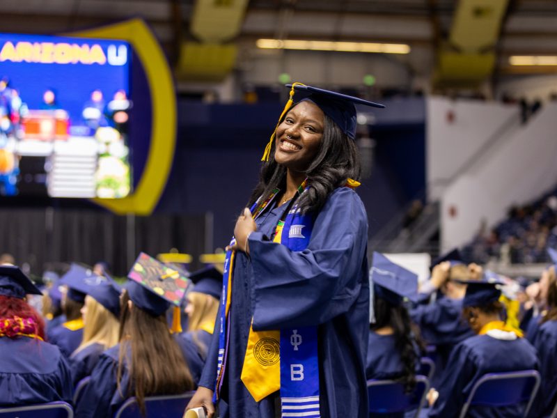 A student smiles for the camera at commencement.