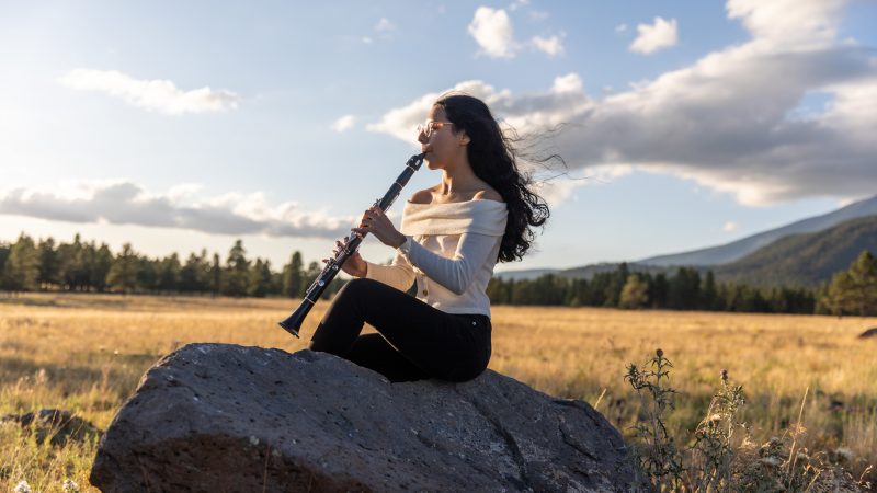 An N A U student plays the clarinet at Buffalo Park in Flagstaff.