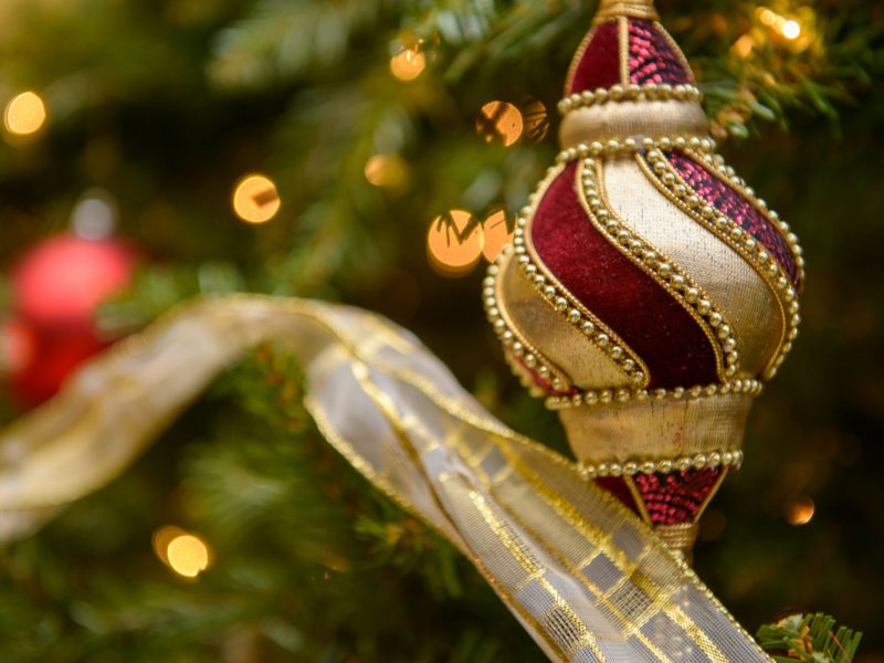 A decorated Christmas tree with red and gold ornaments and glowing lights.