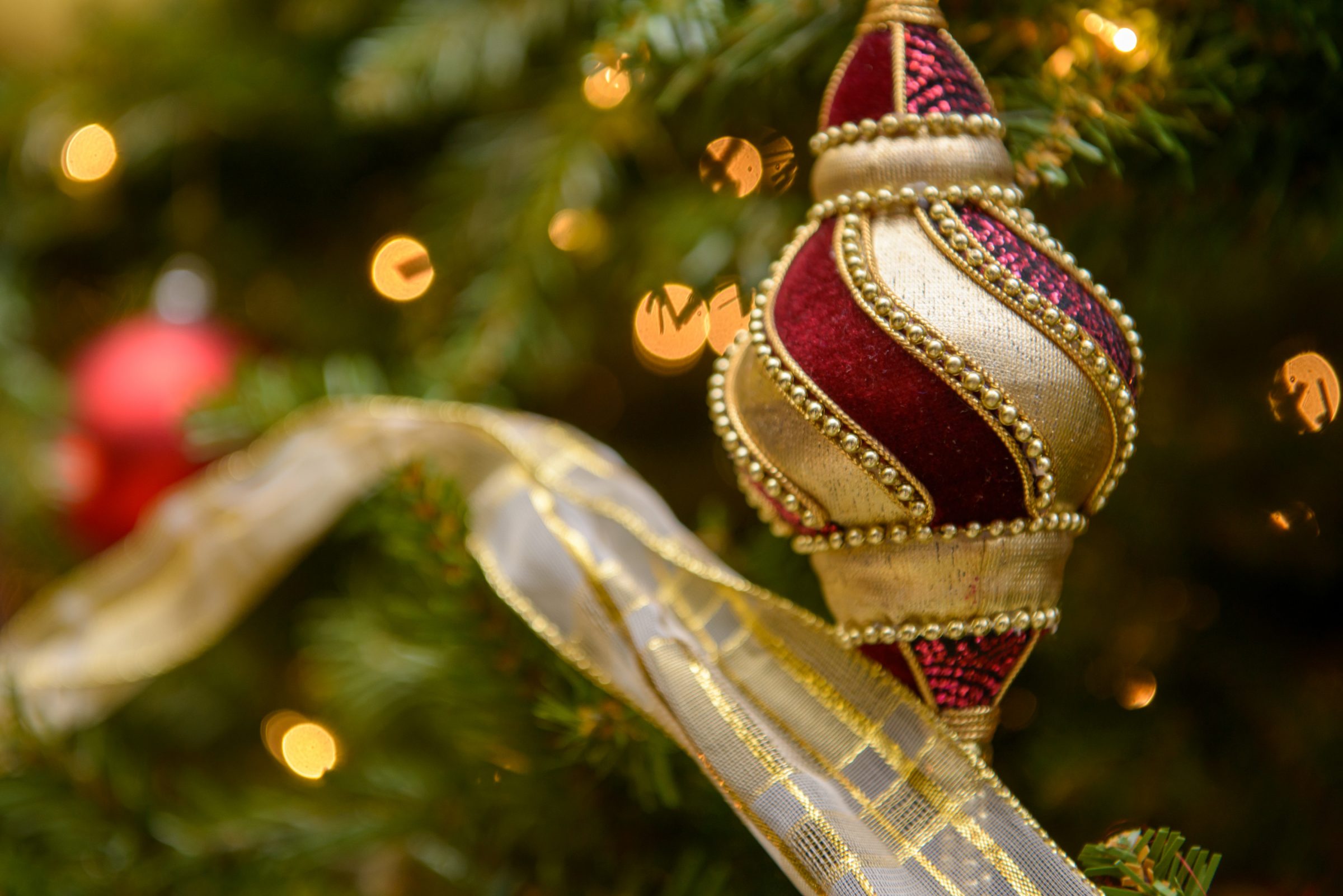 A decorated Christmas tree with red and gold ornaments and glowing lights.