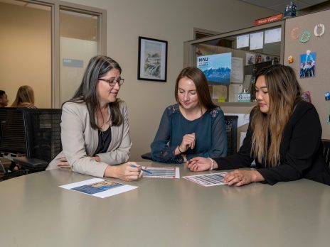 A NAU professor assisting two students in analyzing their work