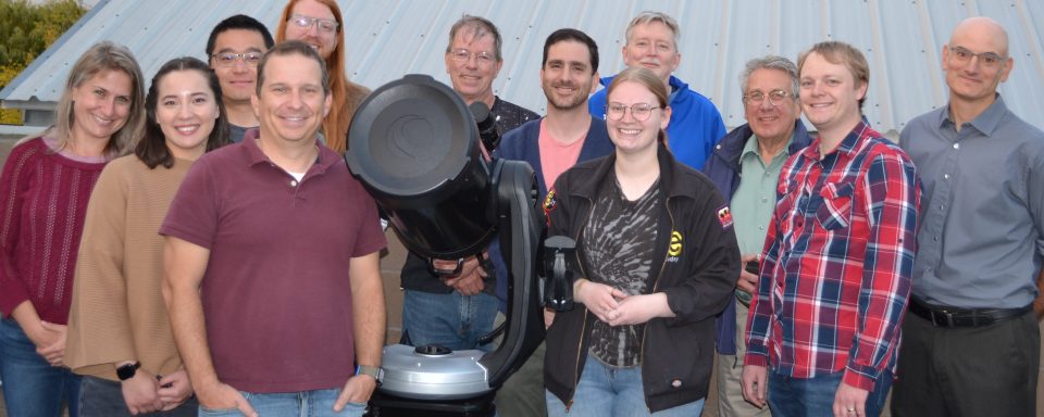 APS faculty, staff, and students with one of the new telescopes.