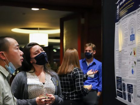 Amanda Hunter speaks with an individual during poster presentations