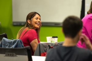 A smiling workshop attendee listens to a workshop presenter.