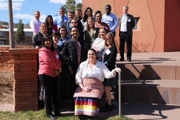 2022 C-CART scholars, faculty and community partners pose for a photo outside the Native American Cultural Center. They are all smiling and standing on the steps in front of the building.