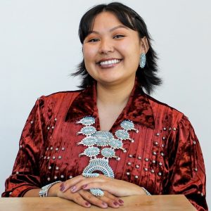 Chassity Begay wearing red traditional clothing with turquoise jewelry