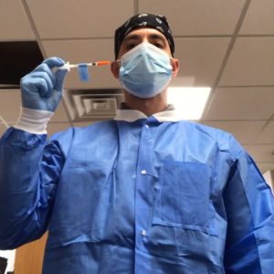 Mike Anastario wearing Personal Protective Equipment while flushing used syringes