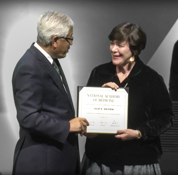 A photograph of Julie Baldwin accepting her induction into the National Academy of Medicine from NAM President Victor Dzau.