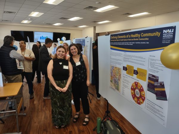 Alexandra Olin and Caroline Mende stand near their poster presentation at the Yuma ABRC Workshop and Conference