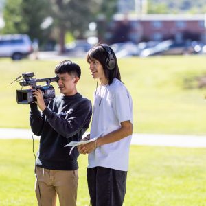 Two students filming outside the Native American Cultural Center.