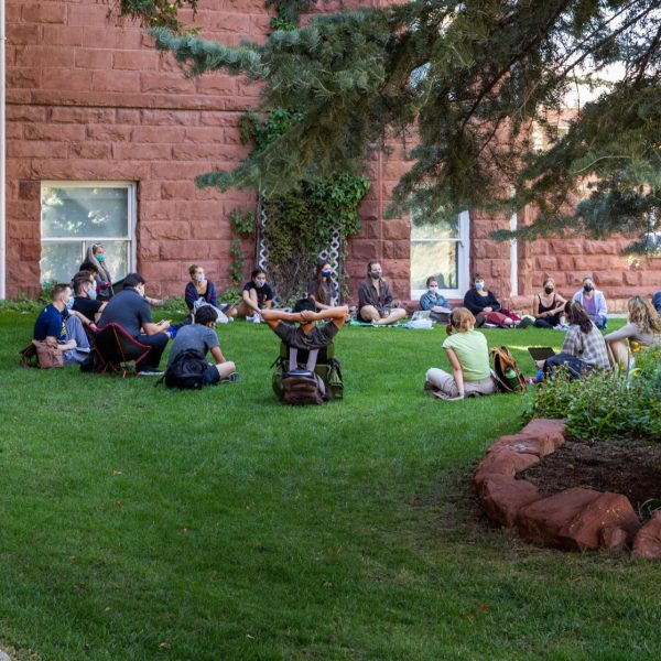 NAU faculty member leading class outdoors while all participants are wearing masks on NAU Flagstaff's North Quad