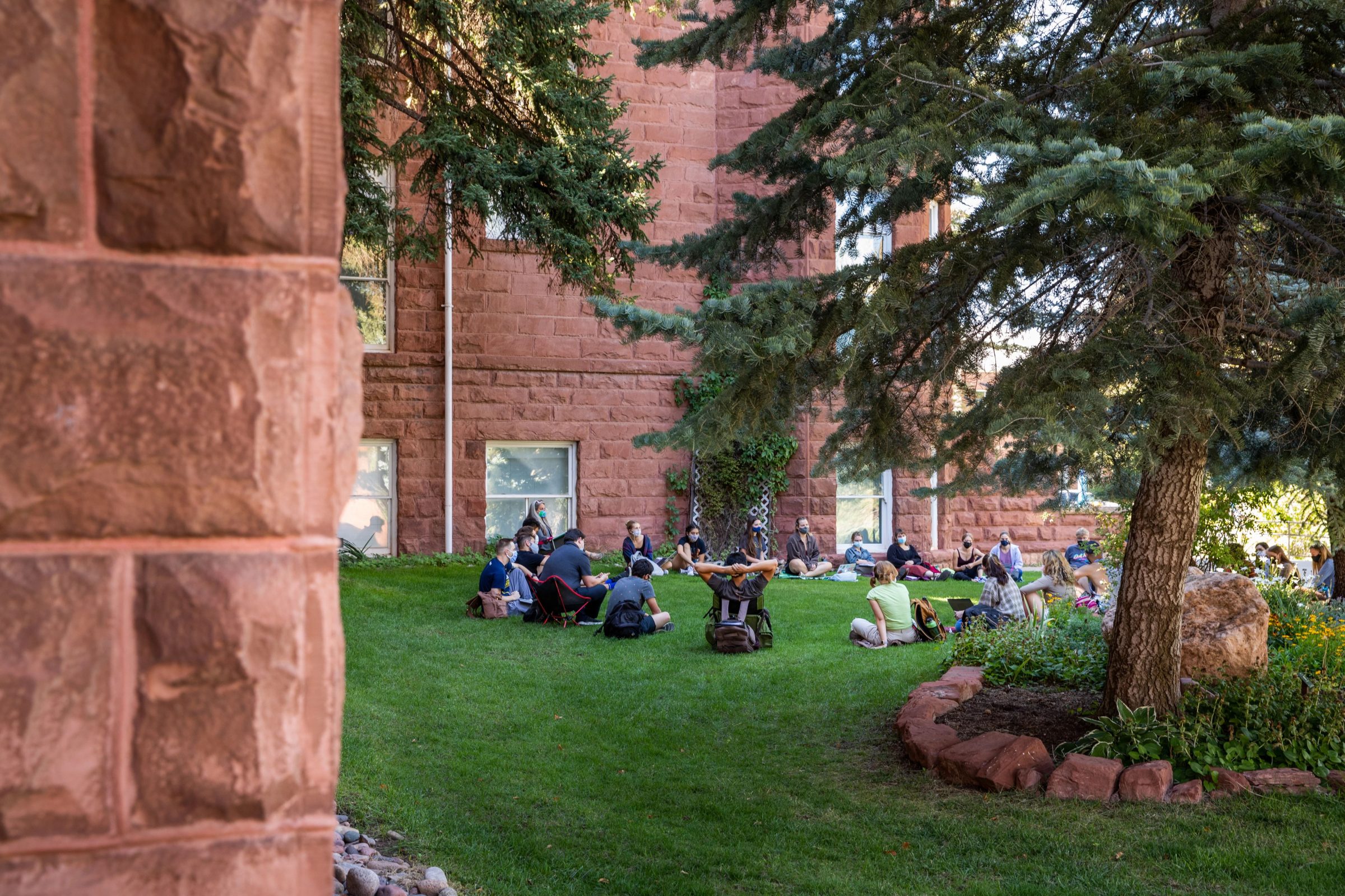 NAU faculty member leading class outdoors while all participants are wearing masks on NAU Flagstaff's North Quad