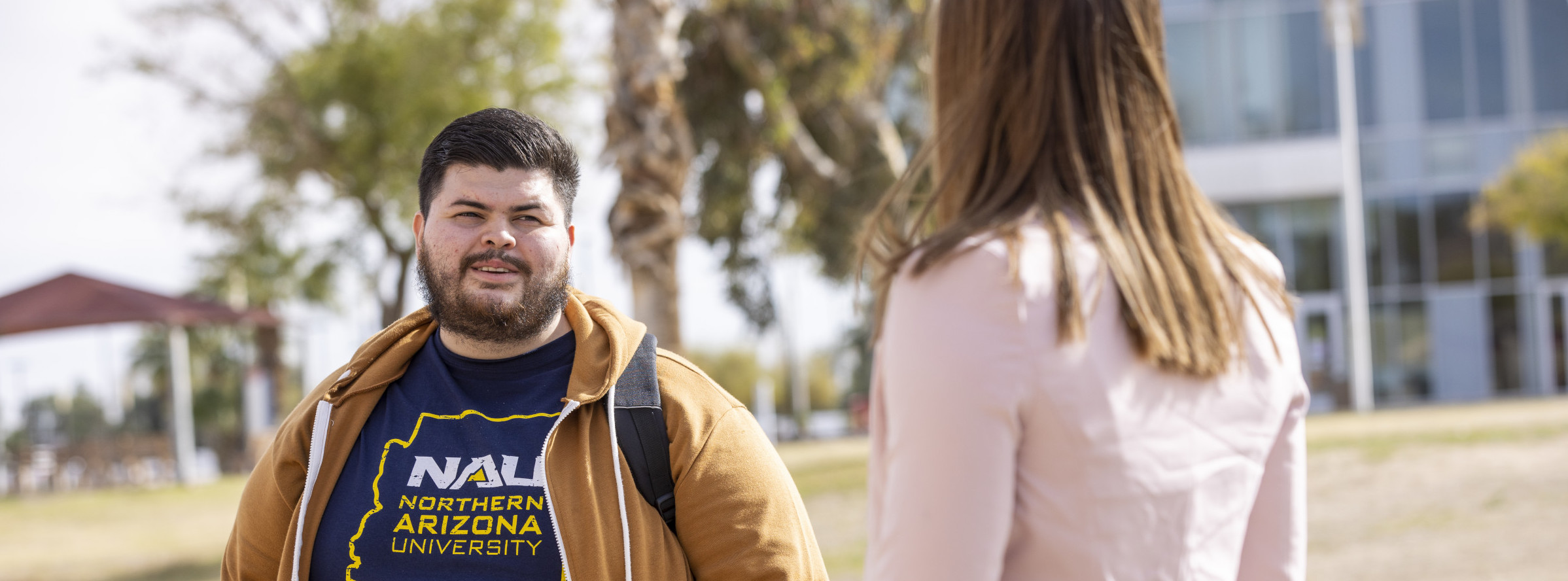 Bryan Vazquez talking with another student on the campus of NAU–Yuma.