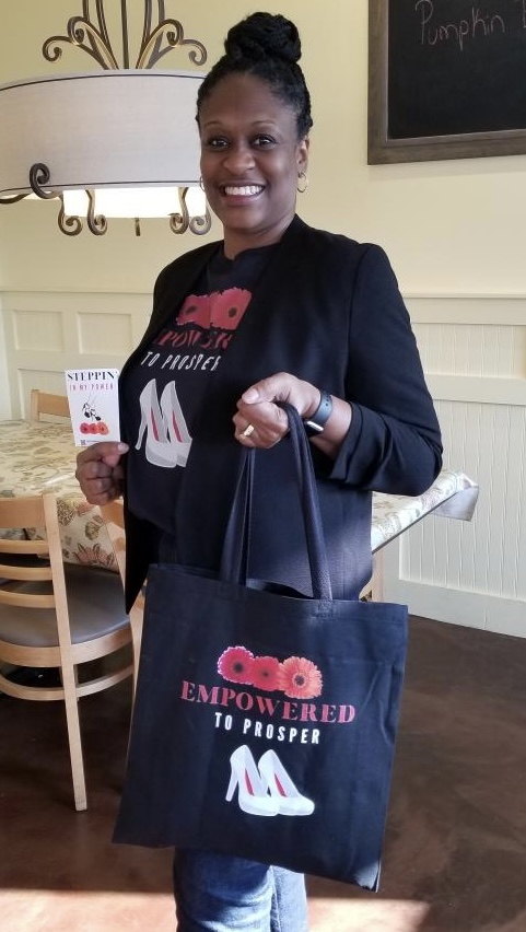 Theresa Bell holding a tote bag made by her company.