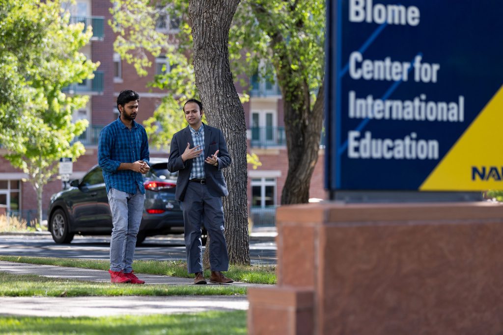 Ragh Singh and student walk on NAU's campus.