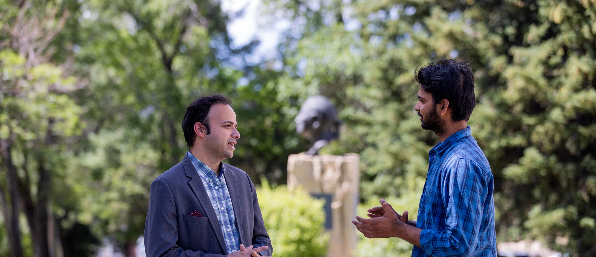 Ragh Singh and student talking outside on NAU's campus.