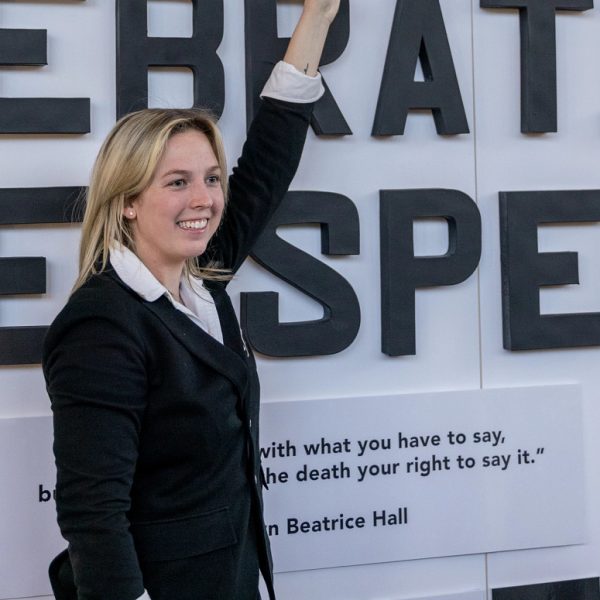 Abigail Brown standing in front of "Celebrating Free Speech" display board at Regents' Cup.