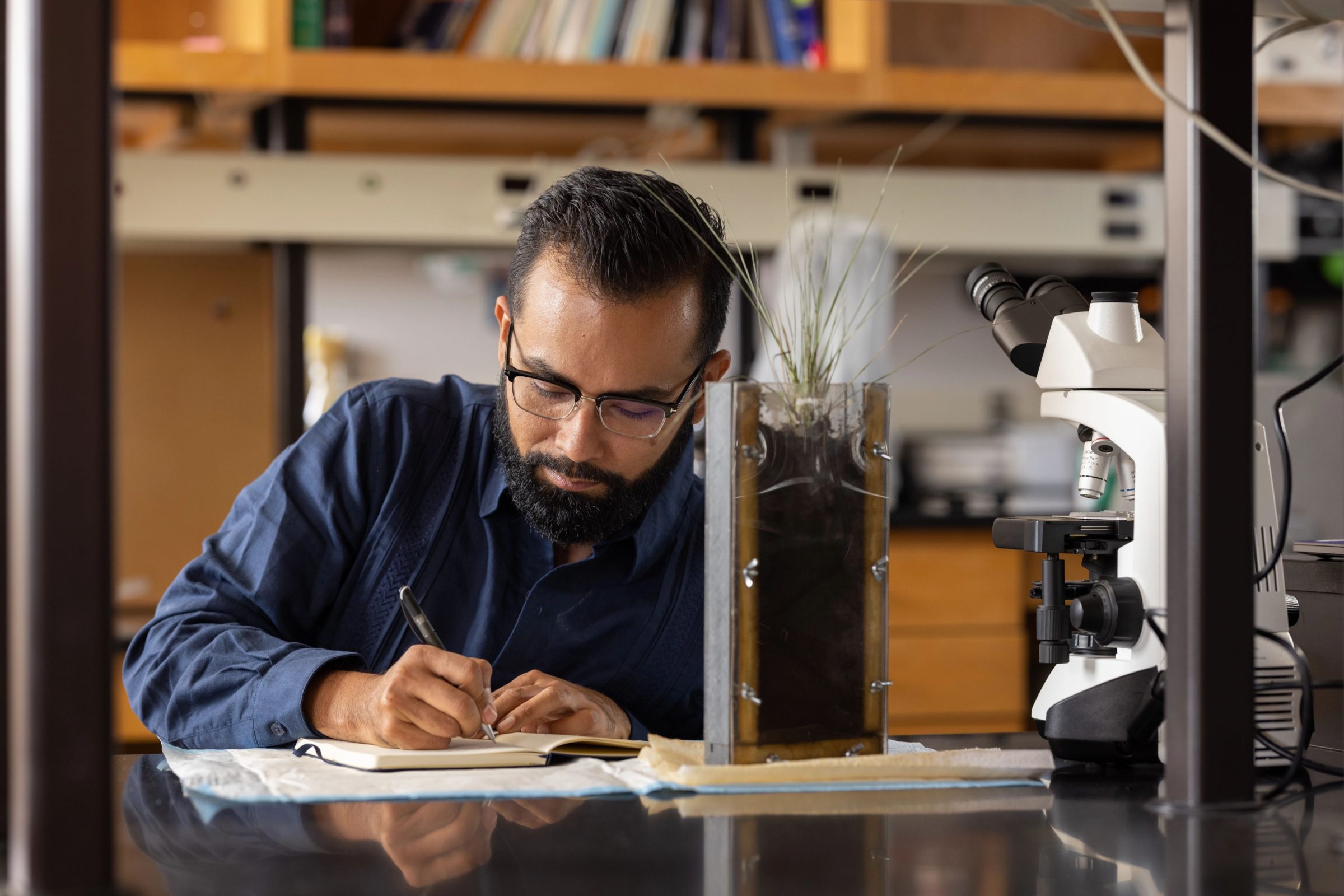 Center for Ecosystem Science and Society Associate Professor Javier Ceja-Navarro writing notes in his lab.