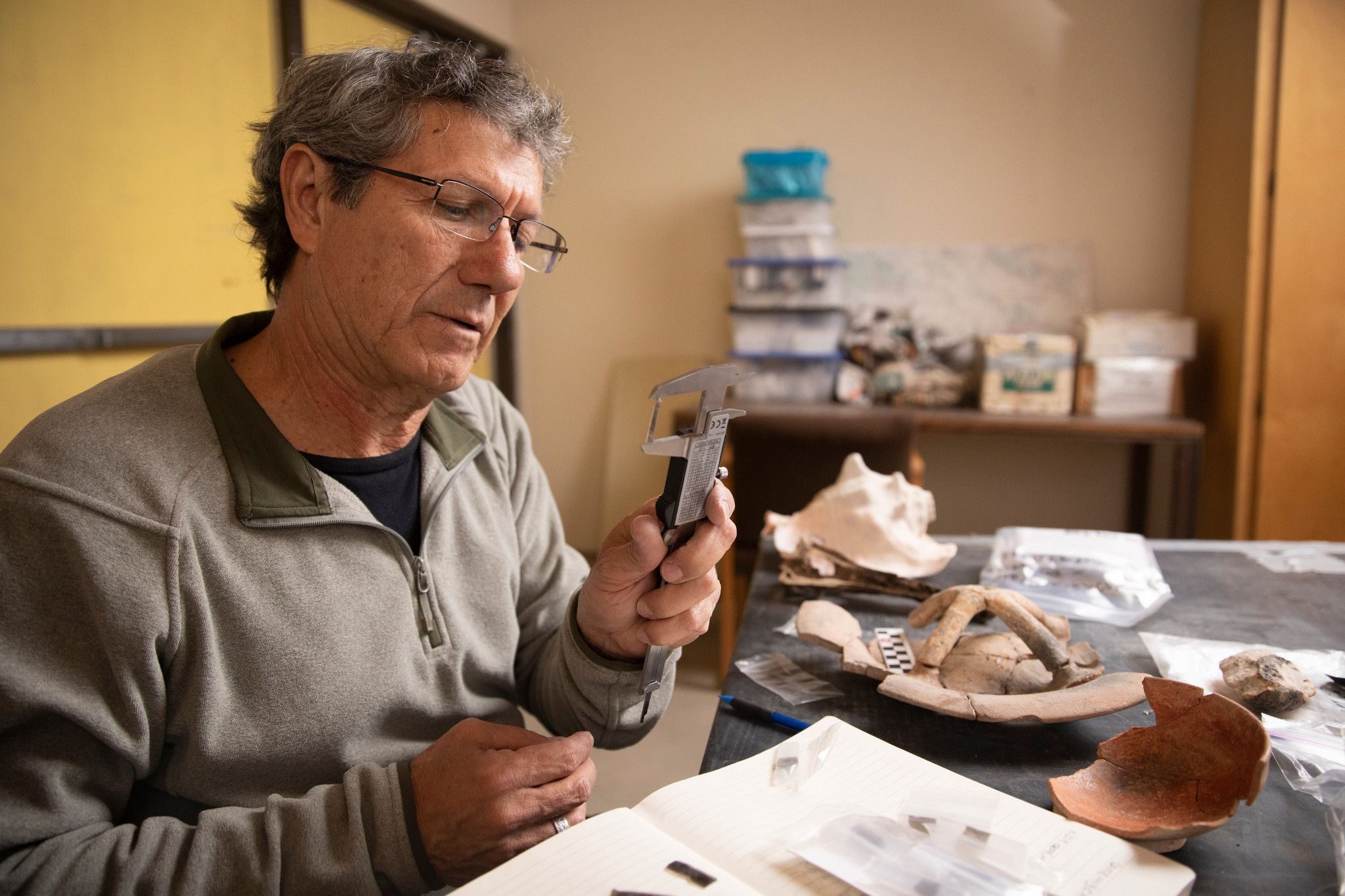 Professor Jaime Awe working with archaeological artifacts in his lab.
