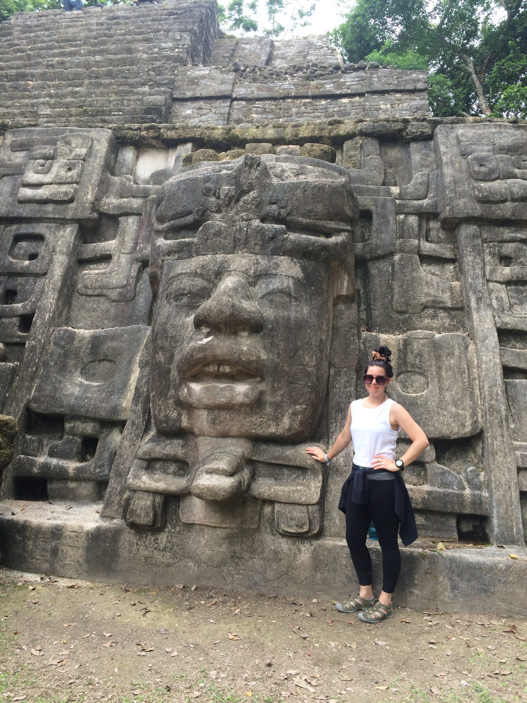 Tia Watkins standing by Mayan ruin in Belize.