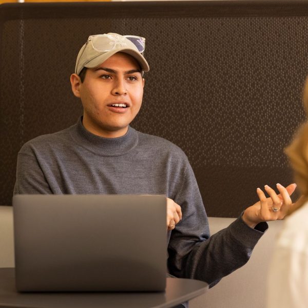 Biomedical sciences student Andres Huerta talking with colleague.