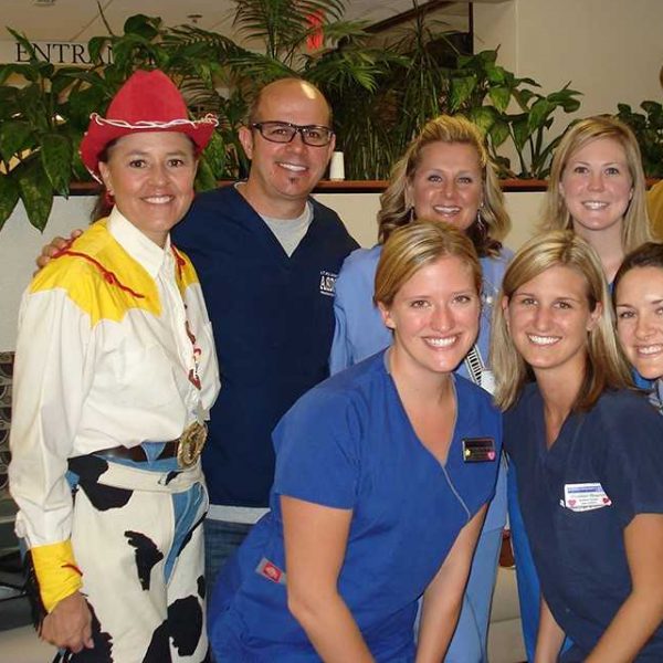 NAU alumna Jenny Zamora-Garcia dressed as Jessie from Toy Story standing with colleagues, as she gets ready for dental health education.