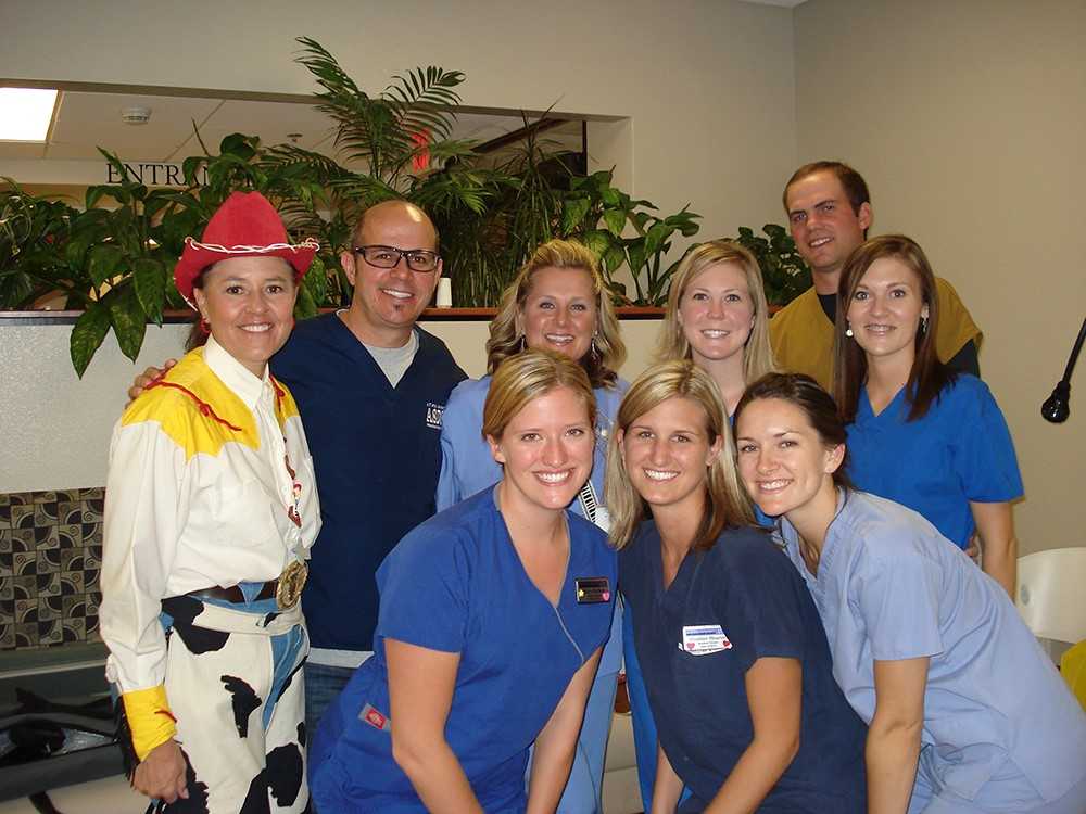 NAU alumna Jenny Zamora-Garcia dressed as Jessie from Toy Story standing with colleagues, as she gets ready for dental health education.
