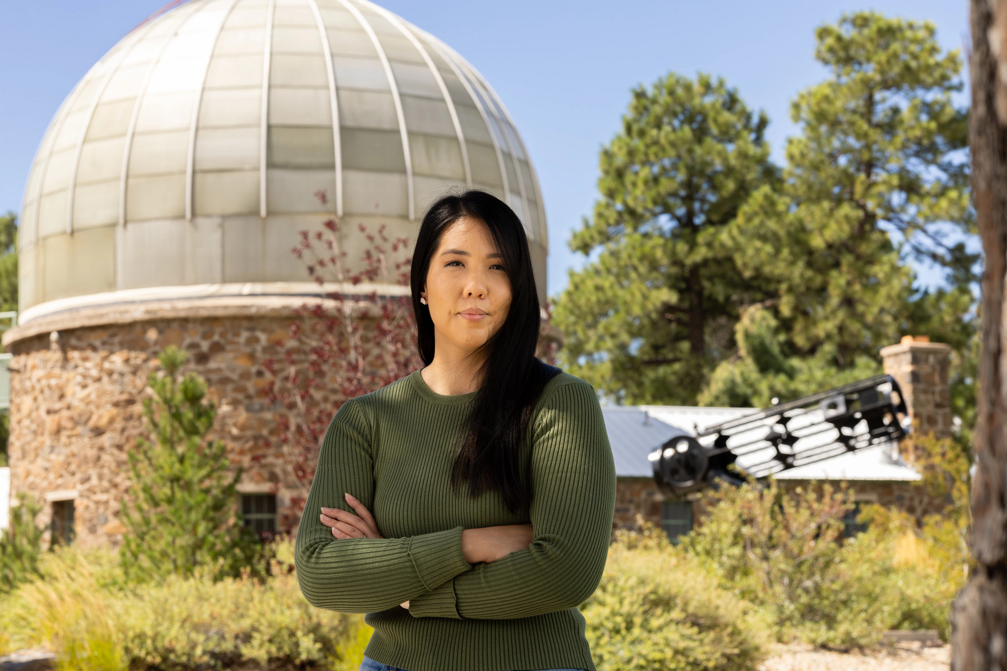 N A U P h D student in Astronomy and Planetary Science Ana Morgan stands outside campus observatory.