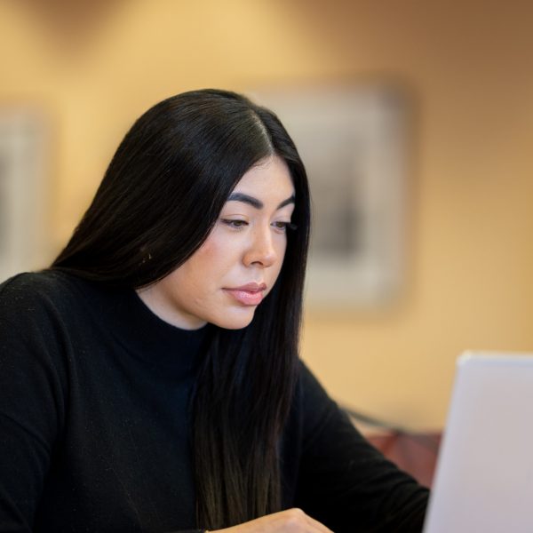 Eileen Magaña, N A U International Affairs graduate, works at her laptop.