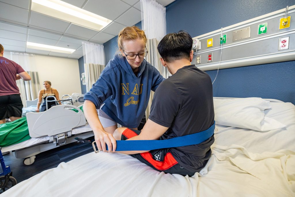 Sara Thomasson, student in NAU’s hybrid Doctor of Physical Therapy program, practices how to move patients on fellow student.