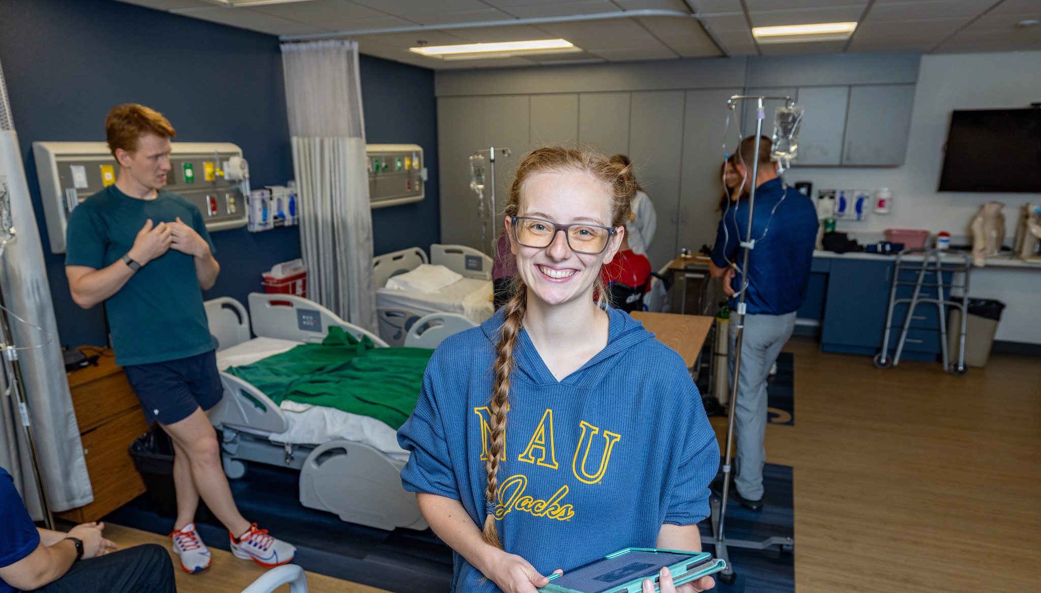 Sara Thomasson, student in NAU’s hybrid Doctor of Physical Therapy program, smiles at camera as other students work in the background.