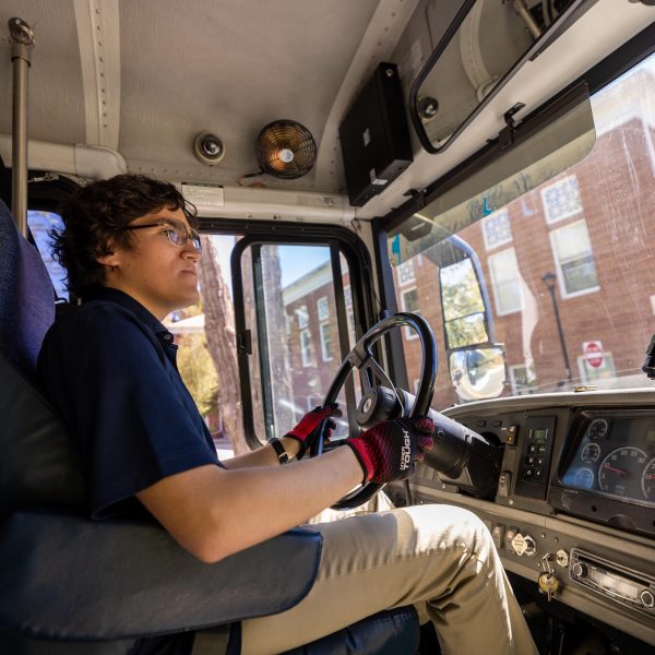 Information Systems major, Daniel Solis driving an NAU shuttle on campus.