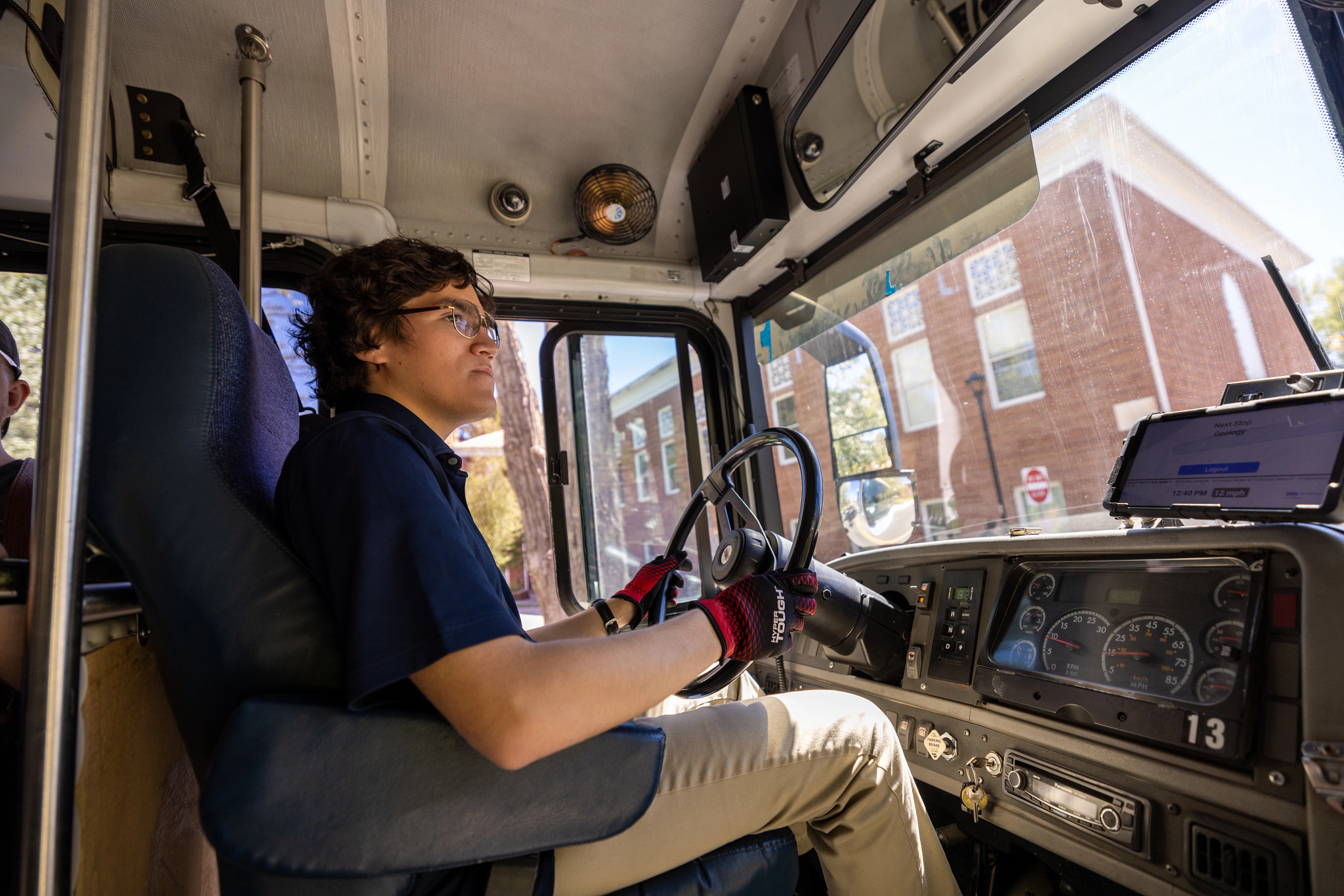 Information Systems major, Daniel Solis driving an NAU shuttle on campus.