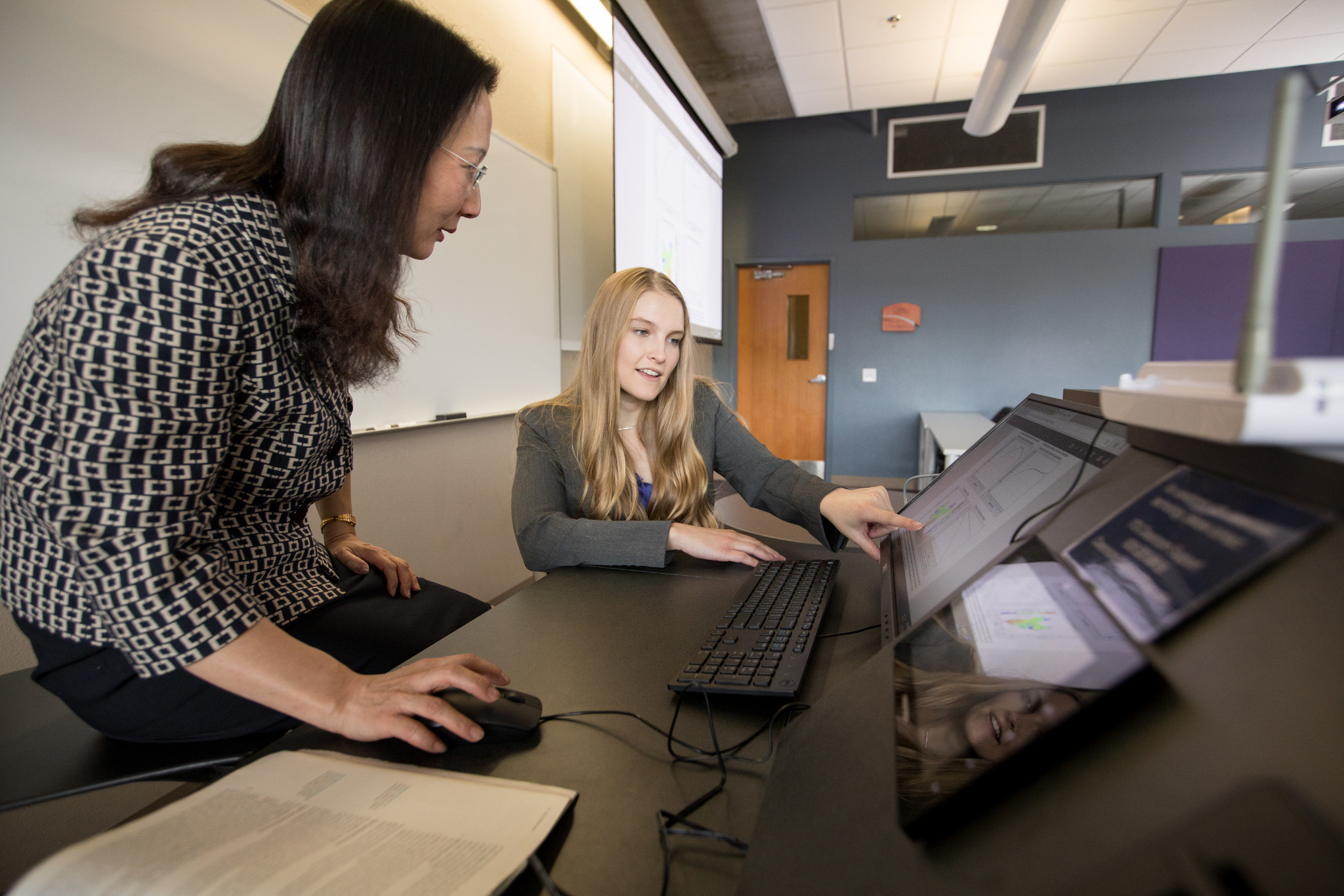 Female professor and female look at a computer screen