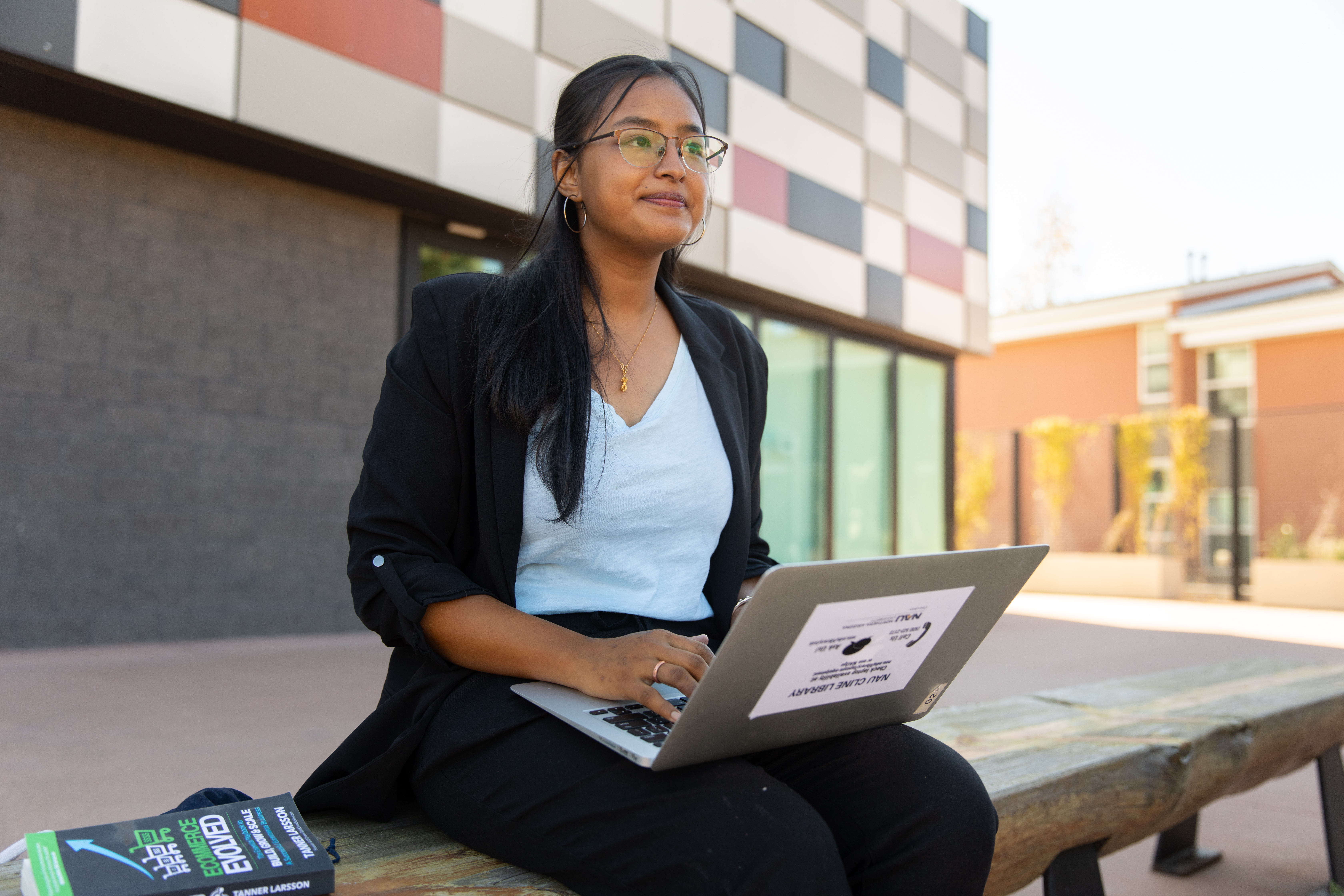 A student sitting outside with her laptop.