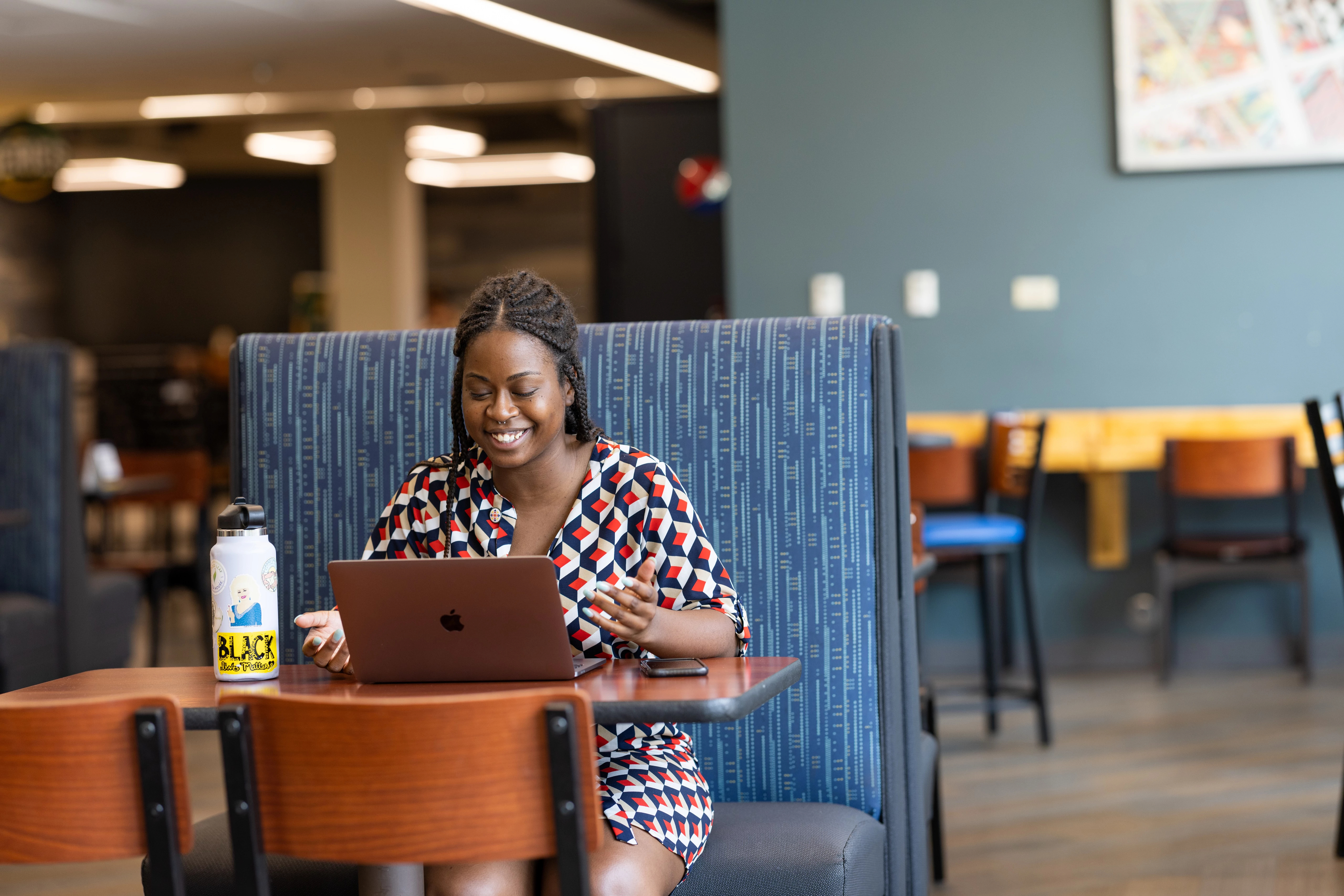 NAU student works on a laptop in a lounge
