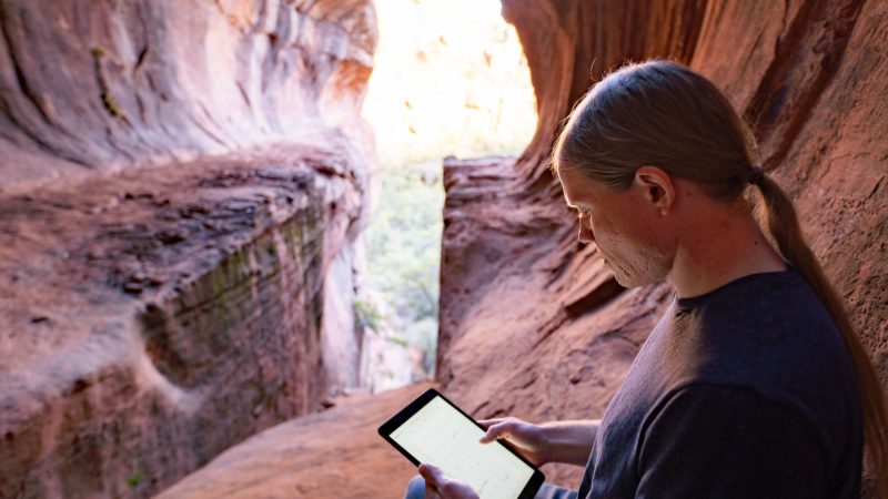 A student participating in an online class while hiking in Sedona.
