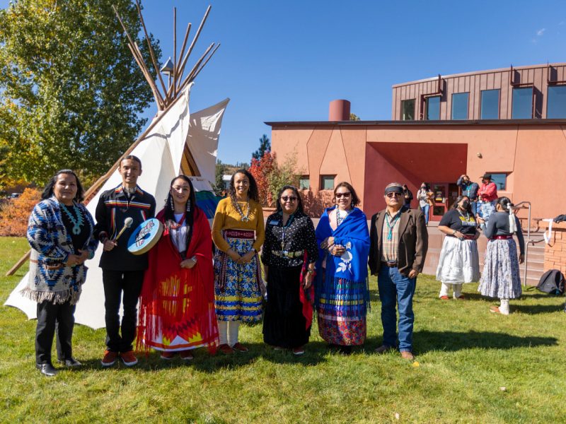 NAU Native American Cultural Center faculty stands in front of tipi smiling