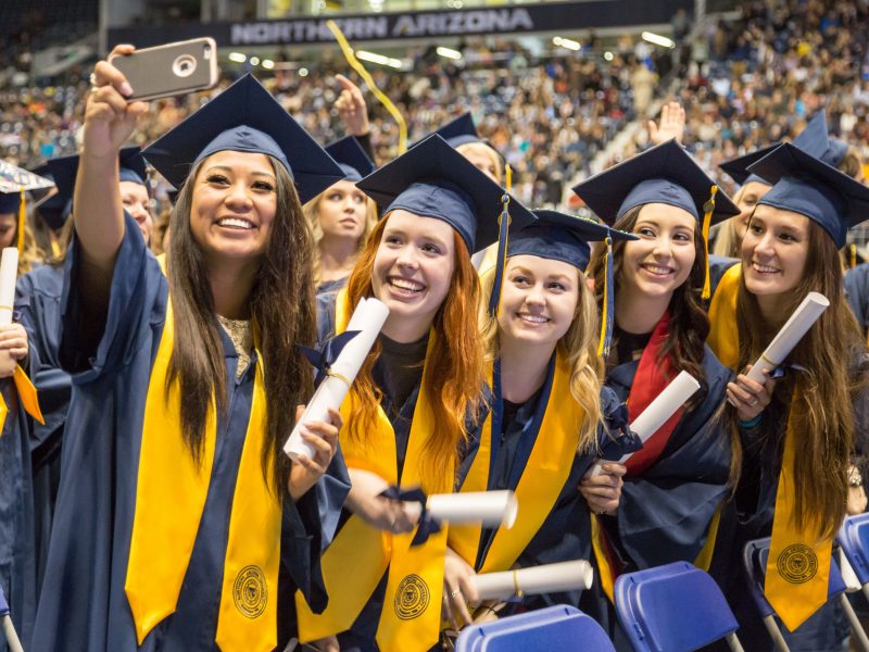 Students take a selfie together during commencement