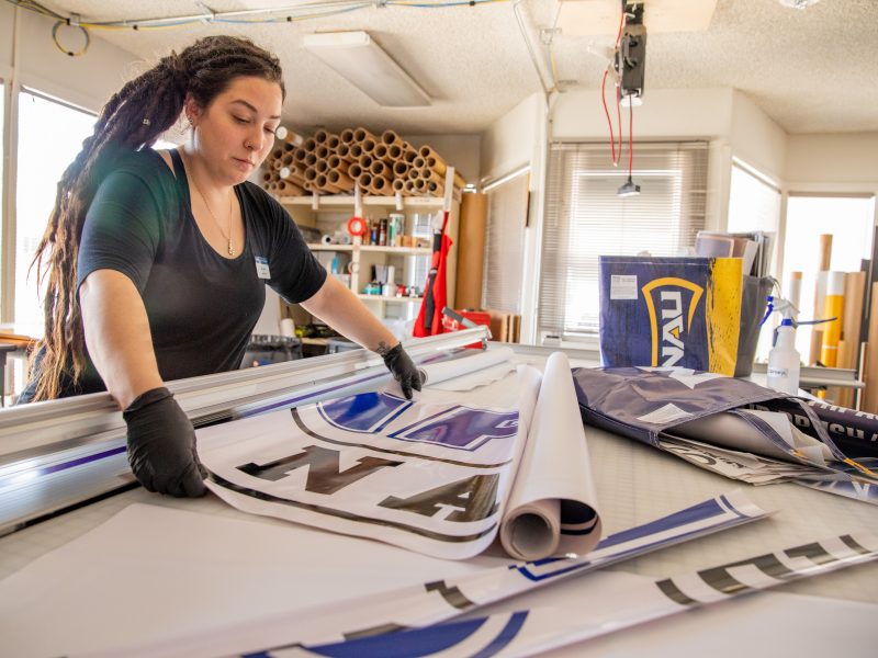 Sara LaRosa works on printing an NAU banner