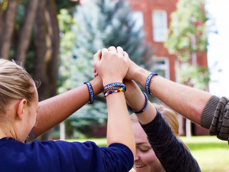 NAU students clasp hands together