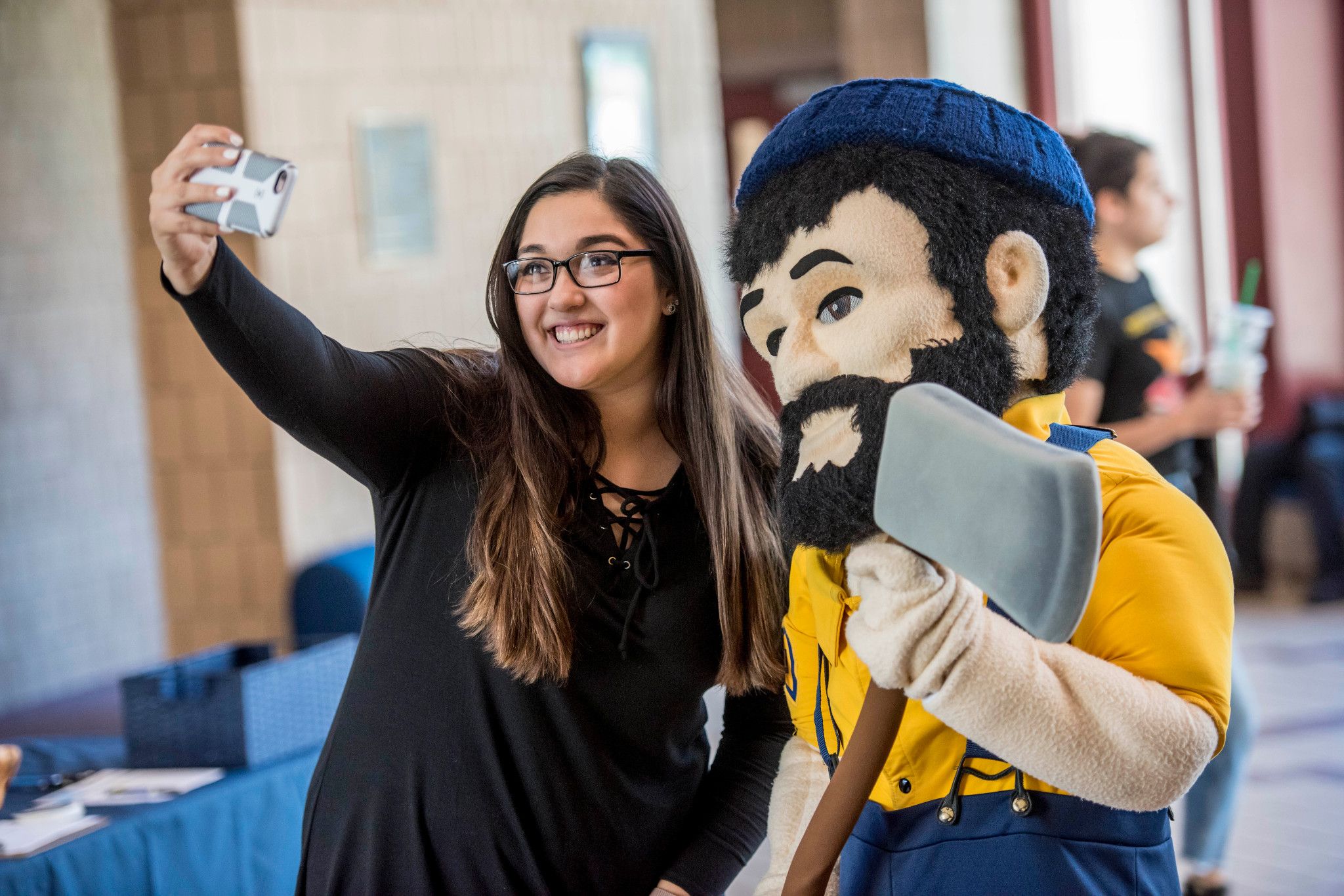 NAU student takes a photo with Louie the Lumberjack