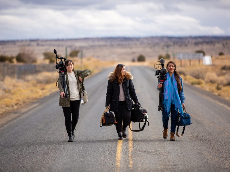 Students walking on a road with camera equipment