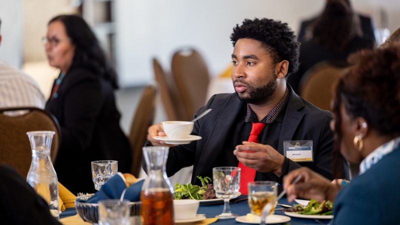 Student sitting at a table during the etiquette luncheon event.