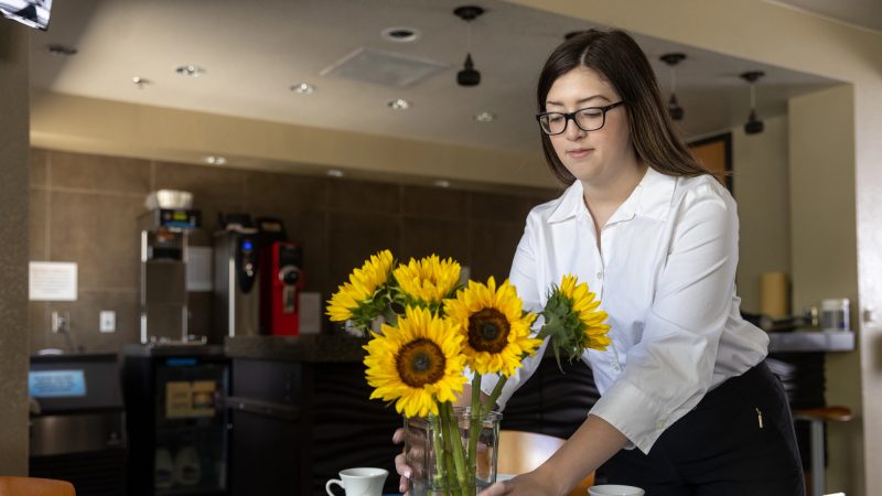 NAU student sets up a table with flowers.