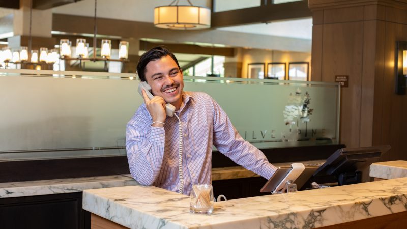 School of Hotel and Restaurant Management student answering phone while working at partner restaurant.