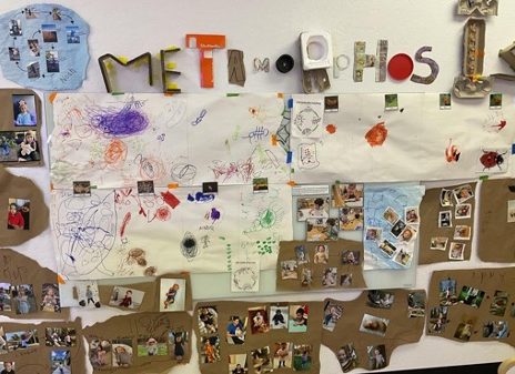 An art display "metamorphosis" with children's photographs and collage materials.