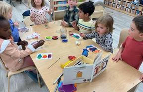 Five children at a table painting with the book Mouse Paint displayed.