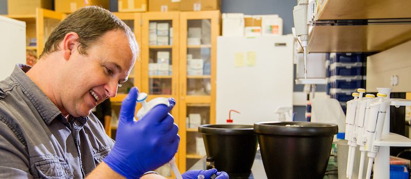 A student holding a syringe in a lab