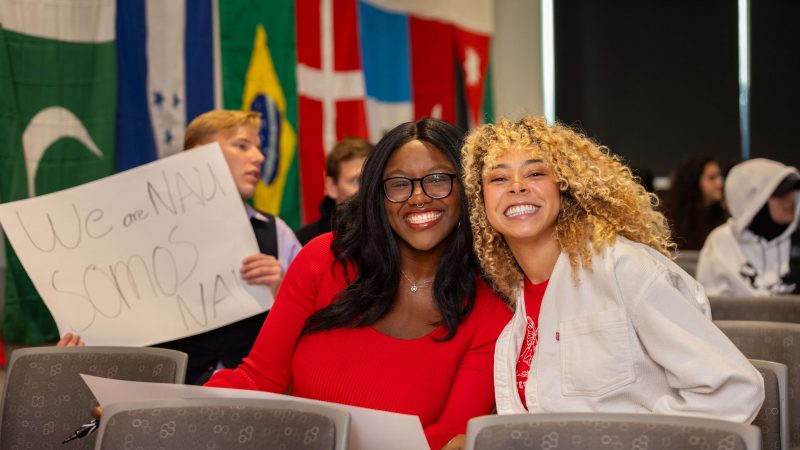 Two international students smiling together at the international graduation